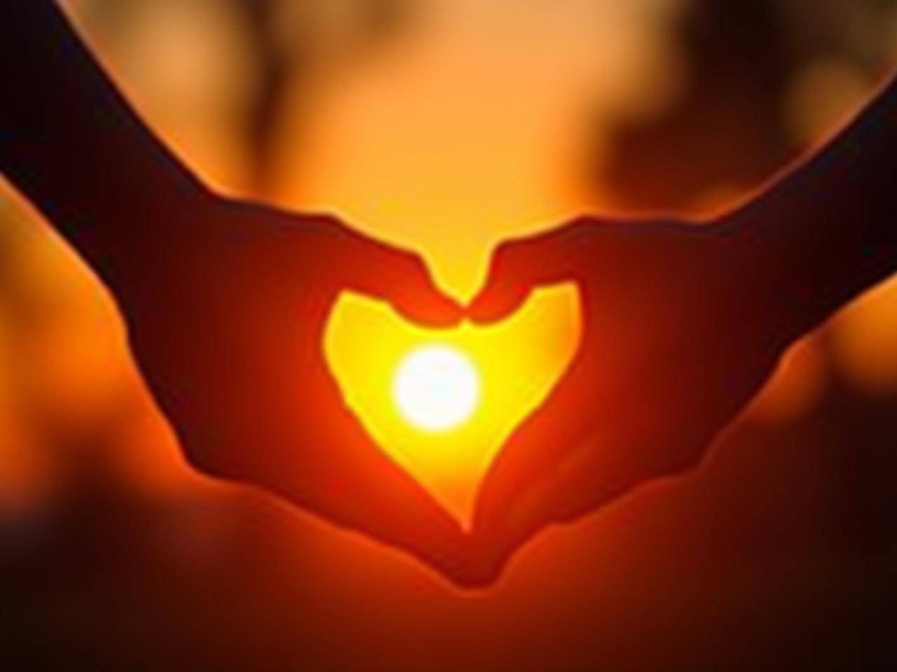 A couple holding hands with a heart-shaped sunset in the background. Keywords: love, relationships, 5 love languages, Gary Chapman, couple, sunset, heart.