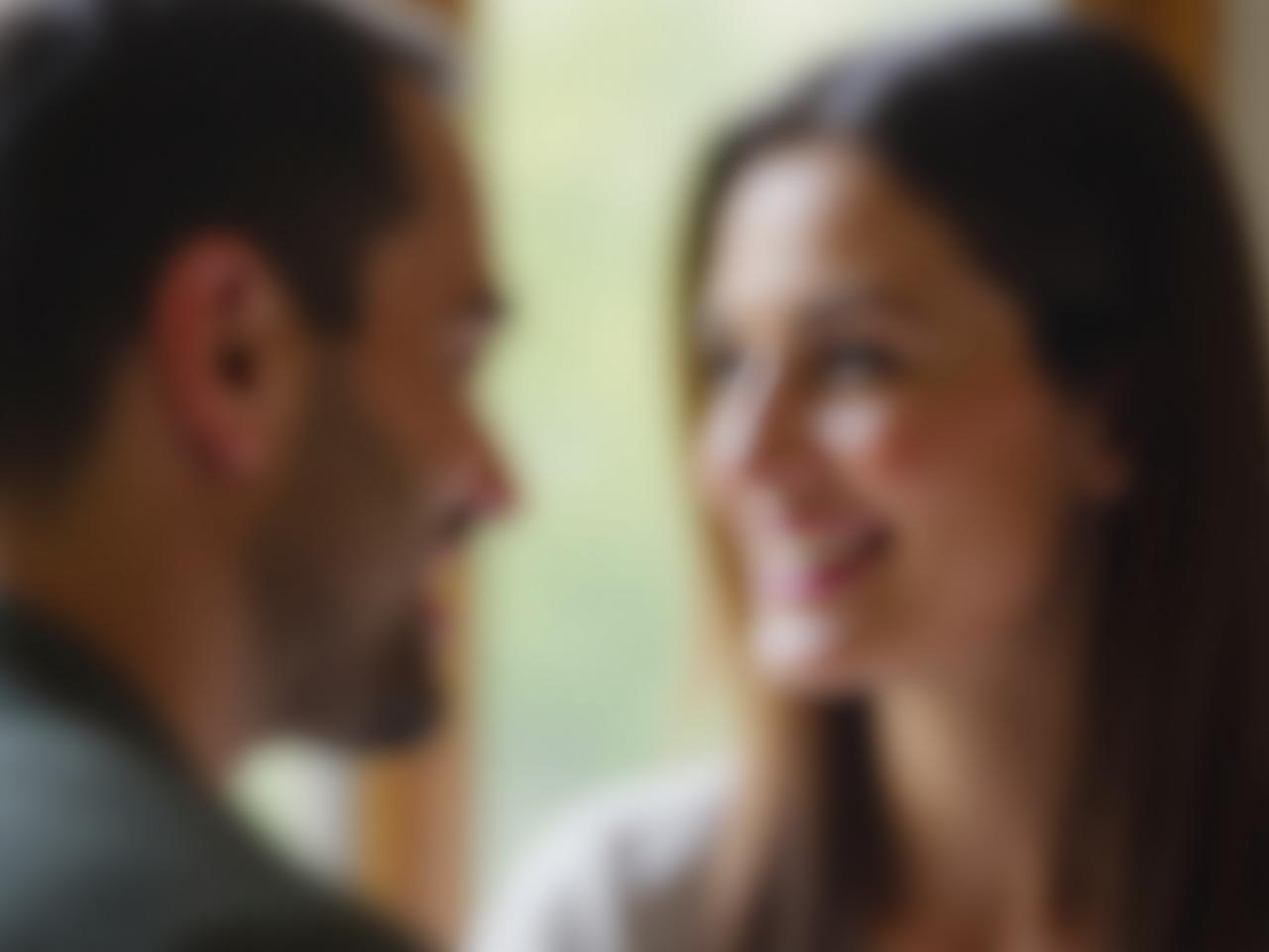 A close-up photo of two people having a conversation, with soft, natural light. The focus is on their facial expressions, showing genuine listening and empathy. The background is blurred to keep the focus on the interaction.